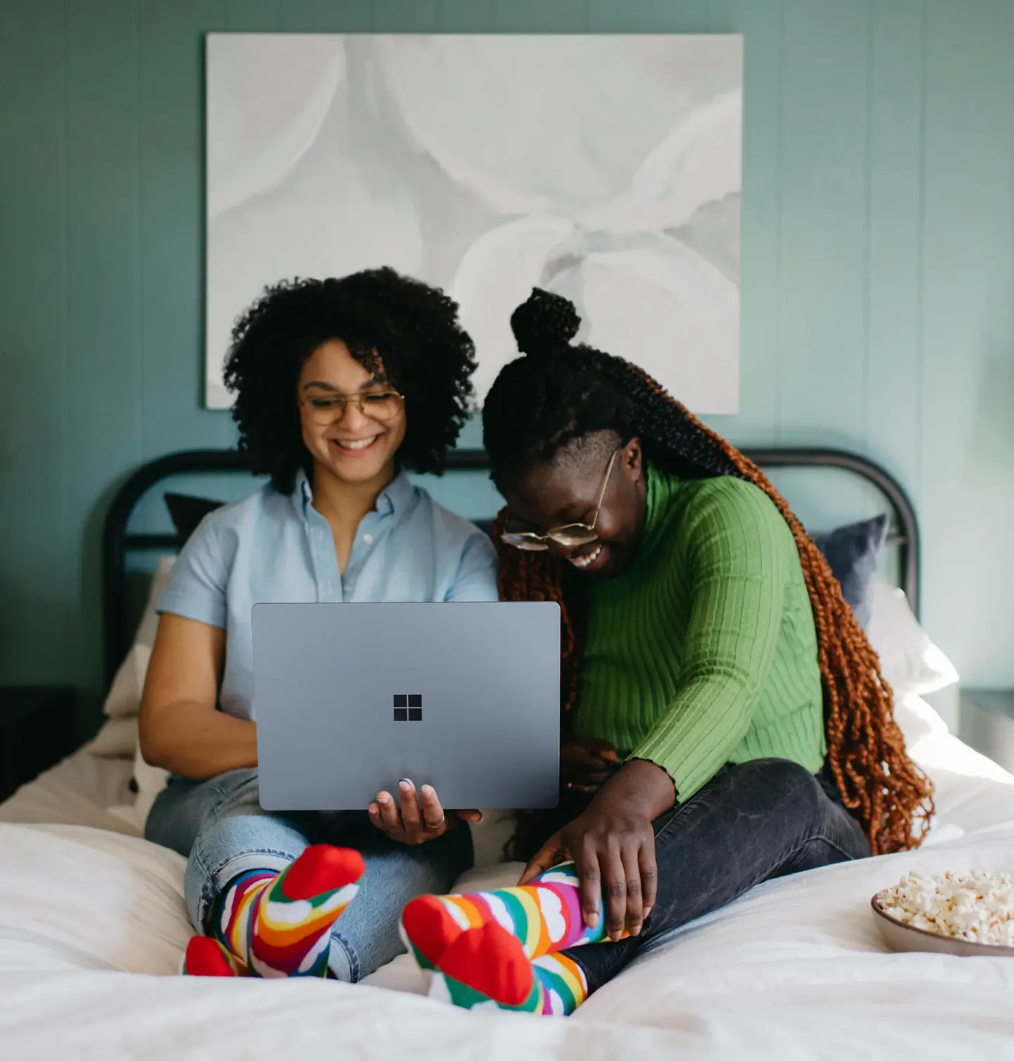 two smiling people looking at laptop screen